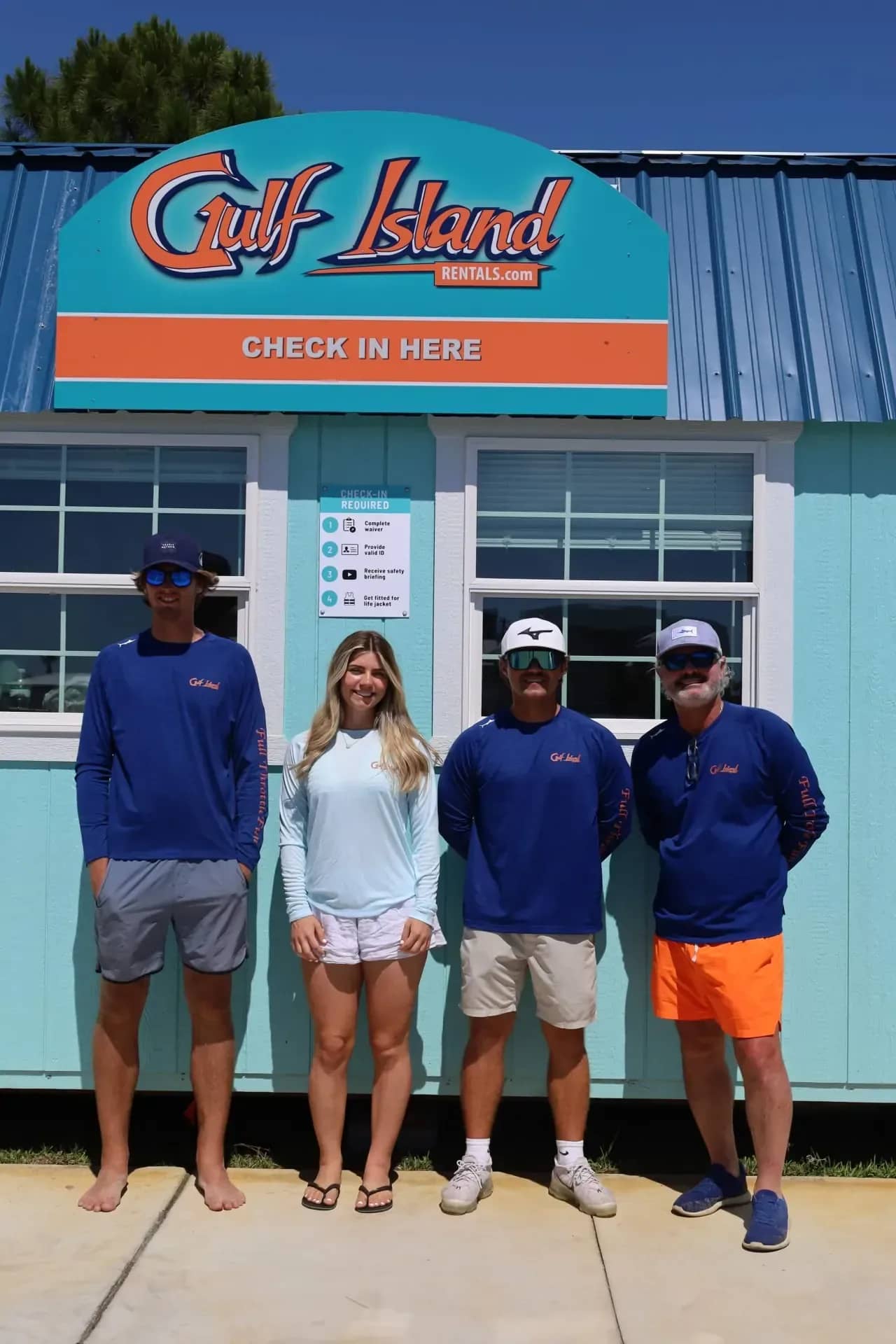 Gulf Island Rentals team standing together at the check-in office, Sunset Isle Marina